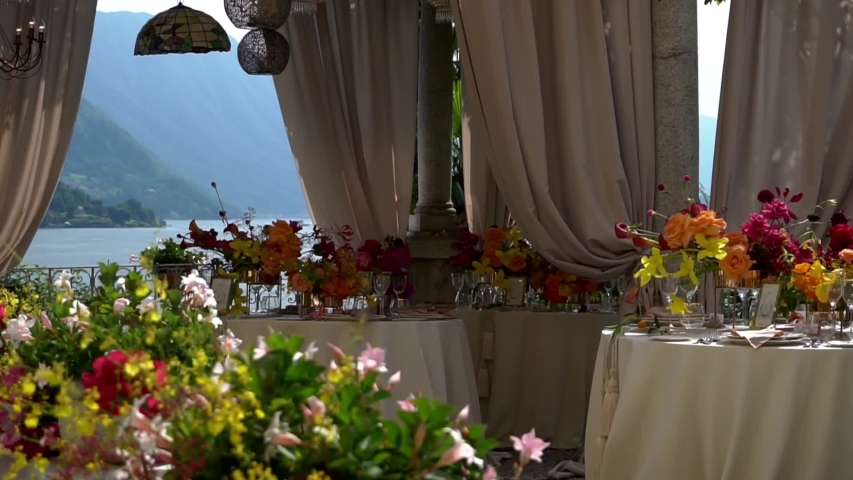 Lake Como in Italy. Cinematic look, decorations and flowers at the wedding dinner. Luxurious romantic luxury wedding. Registration decorations wedding banquet. Lusts. Buffet dinner at a private party Royalty-Free Stock Footage #1033796267