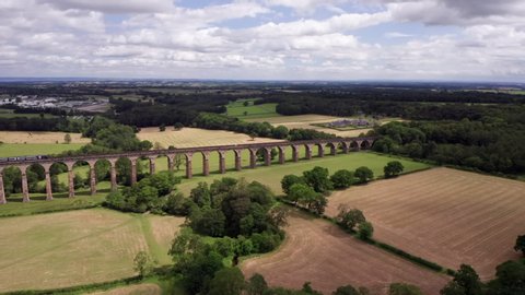 Harrogate, United Kingdom (UK) - 07 06 2019: Downward Dolly Shot of Northern Train Crossing Crimple Valley Viaduct in North Yorkshire on a Summer’s Day