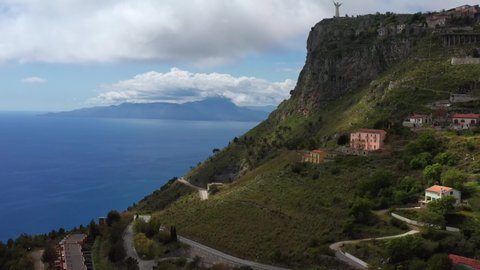 Magnificent cityscape of Maratea hill-town on Tyrrhenian coast in Italy. There is a rocky hill, roads and colorful houses. Aerial video recording with forward motion.