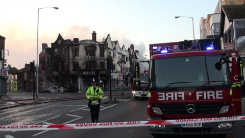 London, United Kingdom (UK) - 08 09 2011: Police officer stands a cordon of a large fire