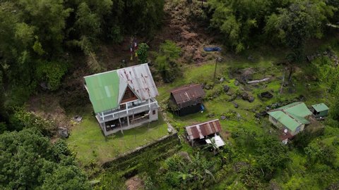 Sikkim, India - 07 10 2019: SIKKIM, INDIA, JUNE 10 - Aerial, reverse, drone shot, tilting away from detached houses, in the middle of Indian forest, on a sunny day, in Sikkim, India