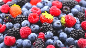 Berries. Various colorful berries rotation background. Mint leaves, Strawberry, Raspberry, Blackberry, Blueberry close-up rotating backdrop. Bio Fruits, Healthy eating, Vegan food, diet. 4K UHD video
