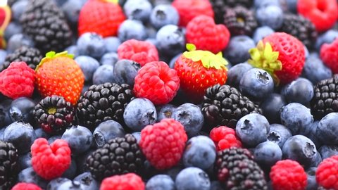 Berries. Various colorful berries rotation background. Mint leaves, Strawberry, Raspberry, Blackberry, Blueberry close-up rotating backdrop. Bio Fruits, Healthy eating, Vegan food, diet. 4K UHD video