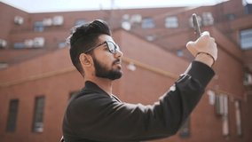 Young indian man make video call on the phone while walking in the street