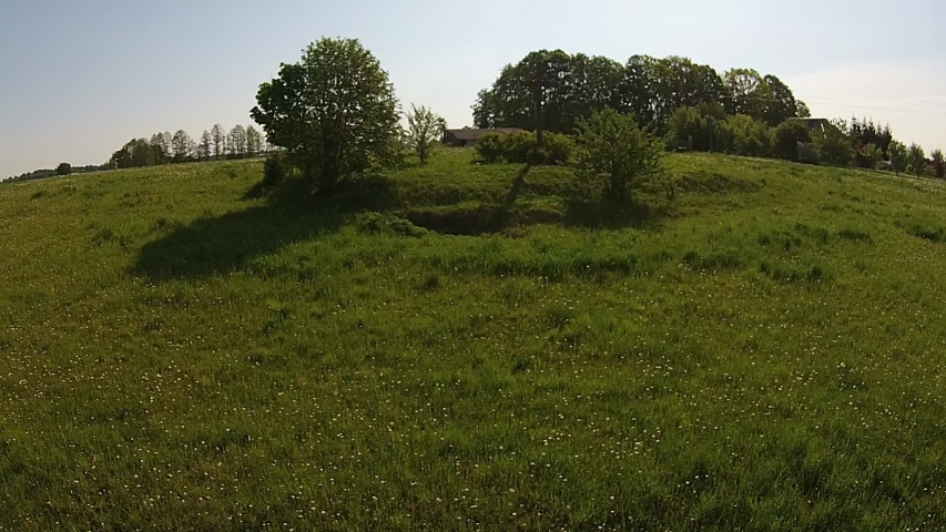 Wooden Cross On A Green Grass Hill And Truck On A Country Road. Aerial Footage.