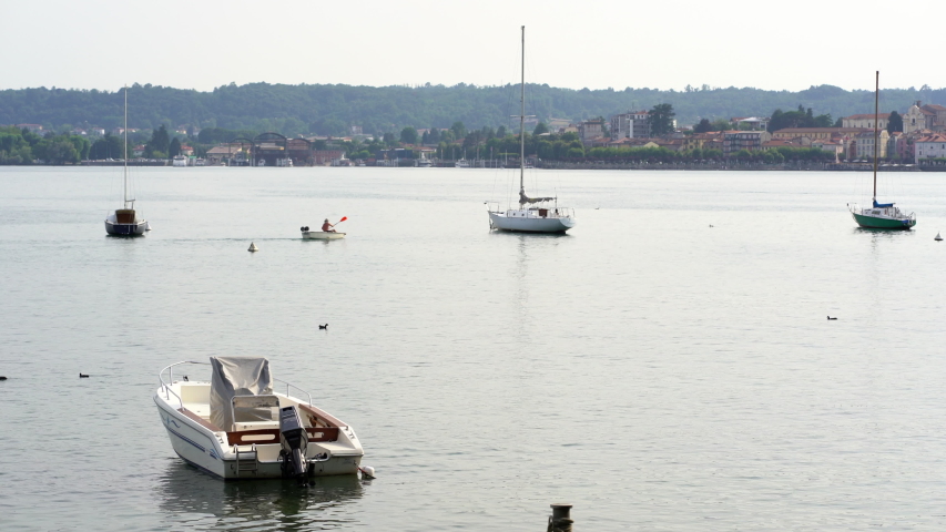 Boats on the lake in Angera, looking at Arona river on lake Maggiore, Italy. 