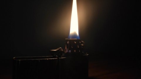 Lighter flame on a table at night
