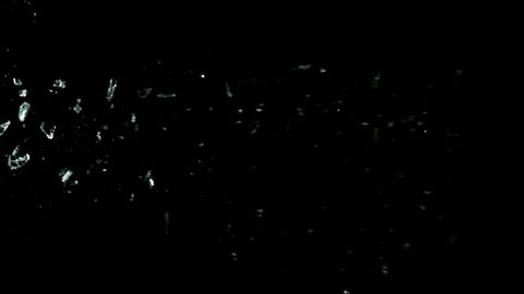 Super slow motion of shattered glass on black background. Filmed on high speed cinema camera, 1000 fps.