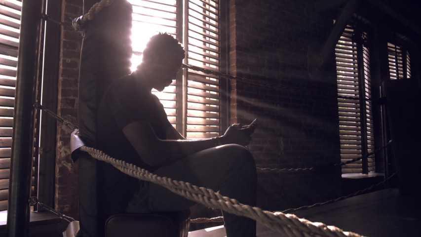 African-american young male boxer sitting in the corner of the ring