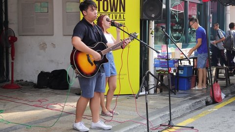 Penang / Malaysia - July 24th 2019: A band is busking at the road side in the city.