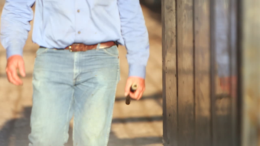 Slow motion shot of a man walking towards the camera in a rural setting