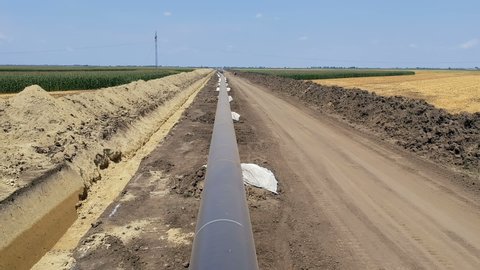 Flying Over Oil or Gas Pipeline Construction Site. Pipes are laid on top of supportive sandbags,welded together and the weld joints coated with epoxy to prevent corrosion. Pipeline under construction.