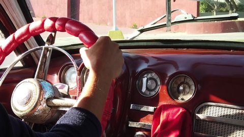 TRINIDAD, CUBA - MARCH, 2019: Driving an American old Cuban car, slow motion detail of the hands on the steering wheel.
