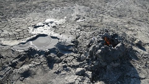 Crater of a gryphon mud volcano in Gobustan, Azerbaijan, with bubbling mud and flaming gas.