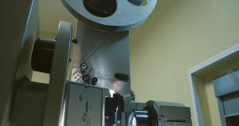 Old 35 mm movie projector working. Rotation film spool reel. Film strip on vintage projector.