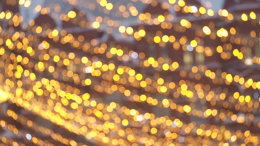 Bright Christmas Street Illumination. The City is Decorated for the Christmastide Holiday. New Year Lights Decorating Shimmering bokeh. Bright festive Christmas abstract background of twinkling