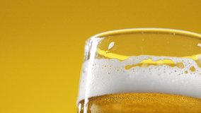 Cold Light Beer in a glass with water drops. Craft Beer close up. Rotation 360 degrees. 4K. Premium cinematic video.