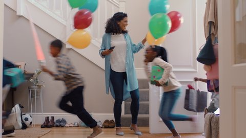 funny birthday party mother opening door with happy children running in house with balloons excited for celebration 4k