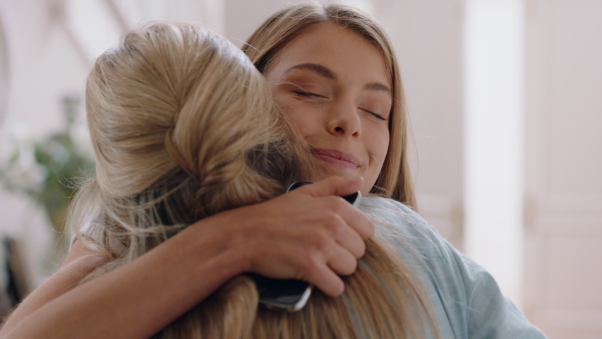 Beautiful teenage girl hugging mother congratulating daughter successful achievement excited mom feeling proud parent enjoying family connection at home 4k footage