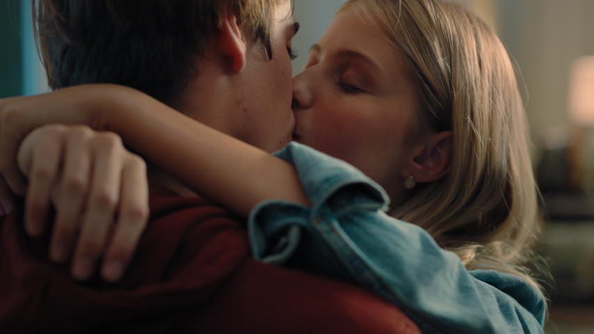 Happy teenage couple first kiss girl kissing boyfriend at home after romantic evening date together 4k | Shutterstock HD Video #1033913855
