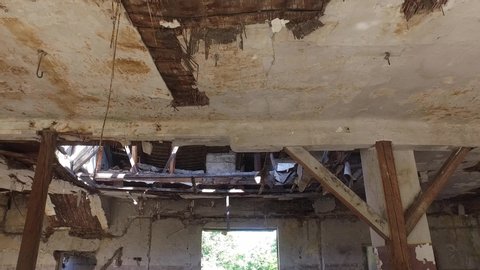 Collapsed roof of the total damaged domestic house indoor from natural disaster or catastrophe with big hole in the ceiling from heavy weather rain storm and water, demolished house concept