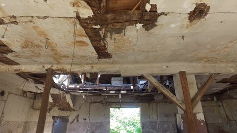 Collapsed roof of the total damaged domestic house indoor from natural disaster or catastrophe with big hole in the ceiling from heavy weather rain storm and water