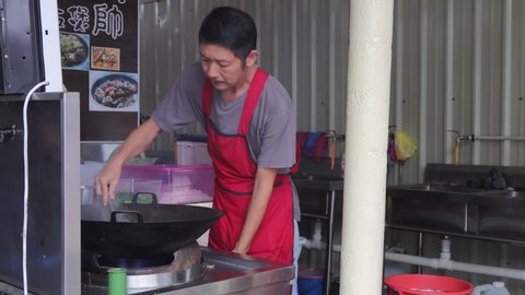 Penang / Malaysia - July 25th 2019: A cook is preparing food for his customer at the food stall.