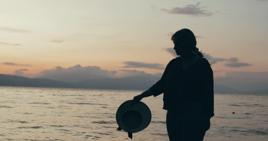 Silhouette of a girl standing at the beach 4k