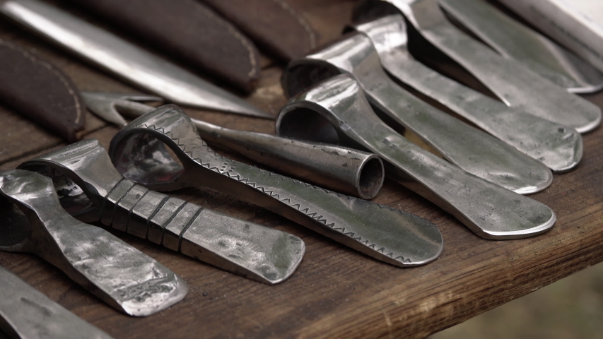 Medieval ax weapon replicas for close combat used in wars on display on wooden table
