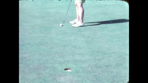 1960s: Golf course. Woman in green shorts putts, misses hole by a foot. Woman in white shorts hunches, putts, misses hole. Man in brown slacks putts and misses.