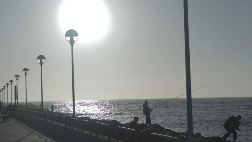 Silhouette of a man fishing at sunset. 