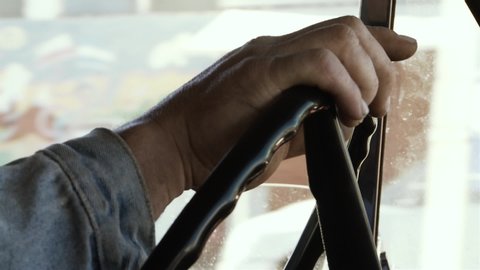 Male Hands On Steering Wheel in an Old Pickup Truck. Close-Up. 