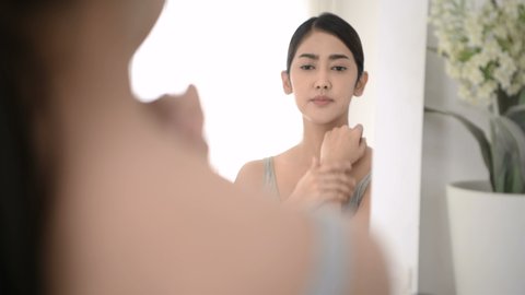 Beauty concept. A woman who looks at the mirror is having problems with irritated skin.