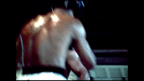 1970s: Man in boxing ring throws jabs at Muhammed Ali. Muhammed Ali and man box in ring.