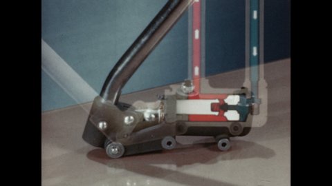 1940s: UNITED STATES: pump on table. Animation of pump and fluid in chamber.