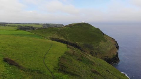Drone footage above the village of Bostcasle, Cornwall looking towards the White Tower (coastwatch station), just visible on the Forrabury headland then panning right to the tiny island of Meachard.
