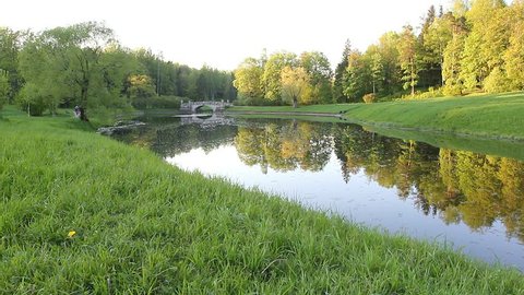 Beautiful landscape in a Park, a forest and a river with ducks. Forest at sunset. Pavlovsk Park, St. Petersburg, view of the ancient bridge