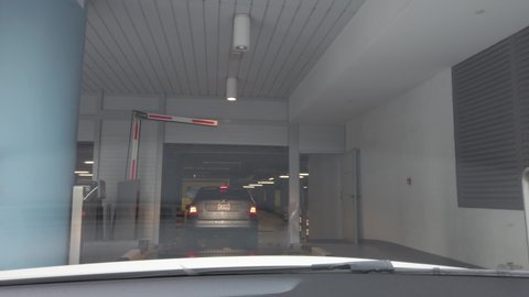 Car entering gated underground parking of a residential - office building. View from the inside of the car