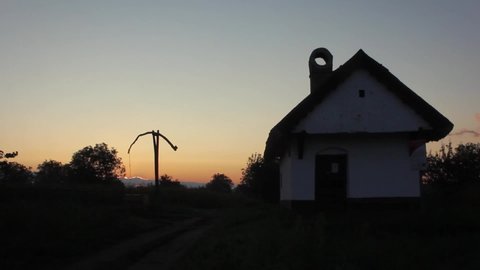Still timelapse of a shadoof and a small house in the colorful sunrise.