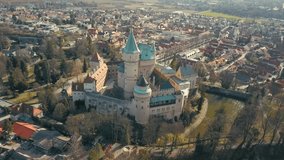 Aerial drone shot, View beautiful landscape on Bojnice castle in city, mountains background in summer sunny day with blue sky, Drone 4K Video