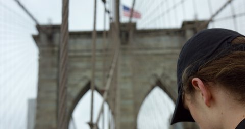 Panning Up Iconic Brooklyn Bridge In Beautiful Manhattan With Slow Motion Of Waving Classic American Flag