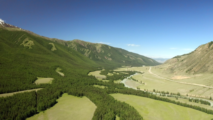 Beautiful spring landscape with mountains, forest and river. Aerial View. Drone shot over a beautiful mountain forest lake.
