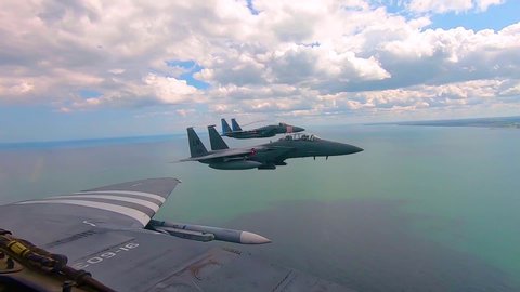 CIRCA 2019, - 48th Fighter Wing heritage F-15 aircraft perform a "missing man" formation over Omaha Beach in honor of the 75th anniversary of D-Day.