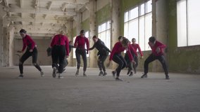 Professional skill dancers girls and boys enjoying hip hop moves performing freestyle dance together in an abandoned building. Caucasian band make modern freestyle dance indoors. Live camera.