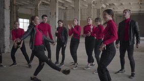 Skillful dancer girls and boys enjoying hip hop moves performing freestyle dance together in an abandoned building. Caucasian band make modern freestyle dance indoors. Hip hop battle