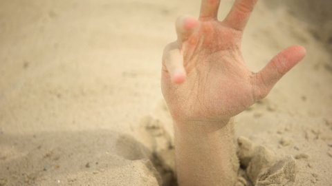 Hand desperately waving, sinking in quicksand, trapped tourist in desert, danger