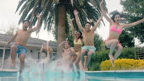 cool friends jumping in swimming pool having fun celebrating summer vacation together group of teenagers enjoying pool party on sunny day underwater view 4k
