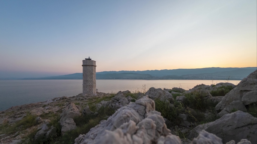 Lighthouse by the sea in the light of the rising sun