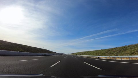 4K, POV view of car driving on highway in the provinces of Seville, southern Spain. A car drives on a freeway. Asphalt with white line at new road.