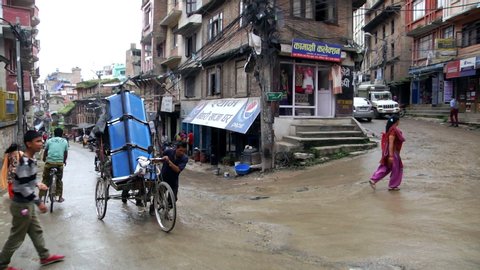 Kathmandu, Nepal - 09 15 2014: Scene in Kathmandu showing man pulling rickshaw up a street with traffic and people around, Nepal